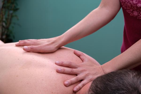 Teku tratando la espalda de un paciente adulto